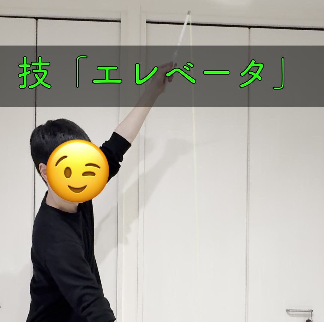 ディアボロのエレベーター技で高く上がったコマとスティックを掲げるしんめ
