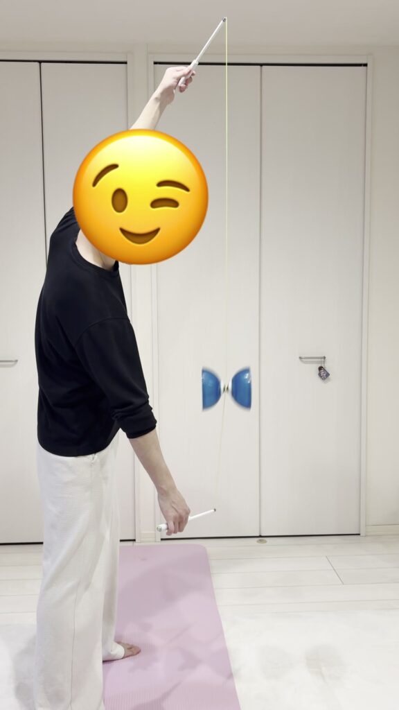 紐を巻き終えて上下のスティックで紐をピンと張り、ディアボロを持ち上げる姿勢のしんめ