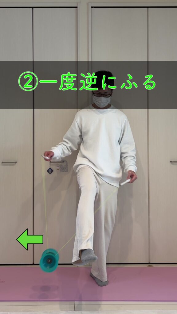 足回りのステップ②でディアボロを普段と逆方向に振って足の下をくぐらせる準備をする様子