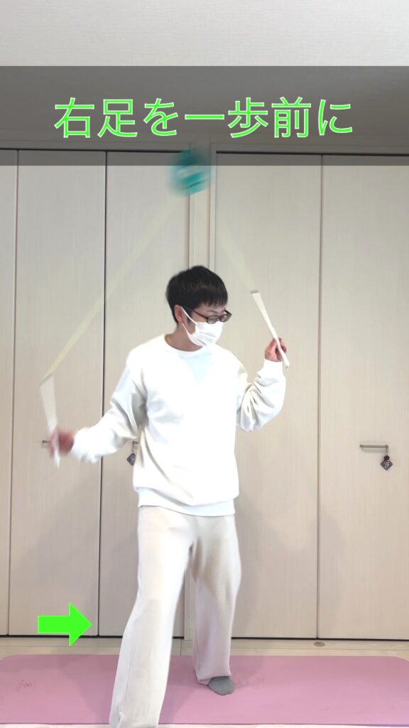 体回りのステップ②で右足を紐の前に一歩踏み出しディアボロを背中側に送り込む様子