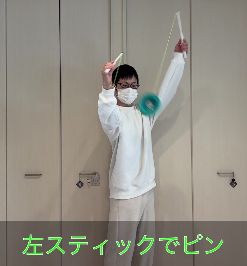 腕回りのステップ③でディアボロが腕下をくぐった後に左スティックで紐をピンと張って軽くトスする様子